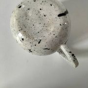 Small speckled ceramic jug in a vintage workshop style.
