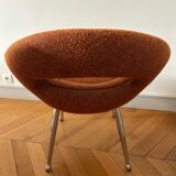 Circular armchair trimmed with orange fabric