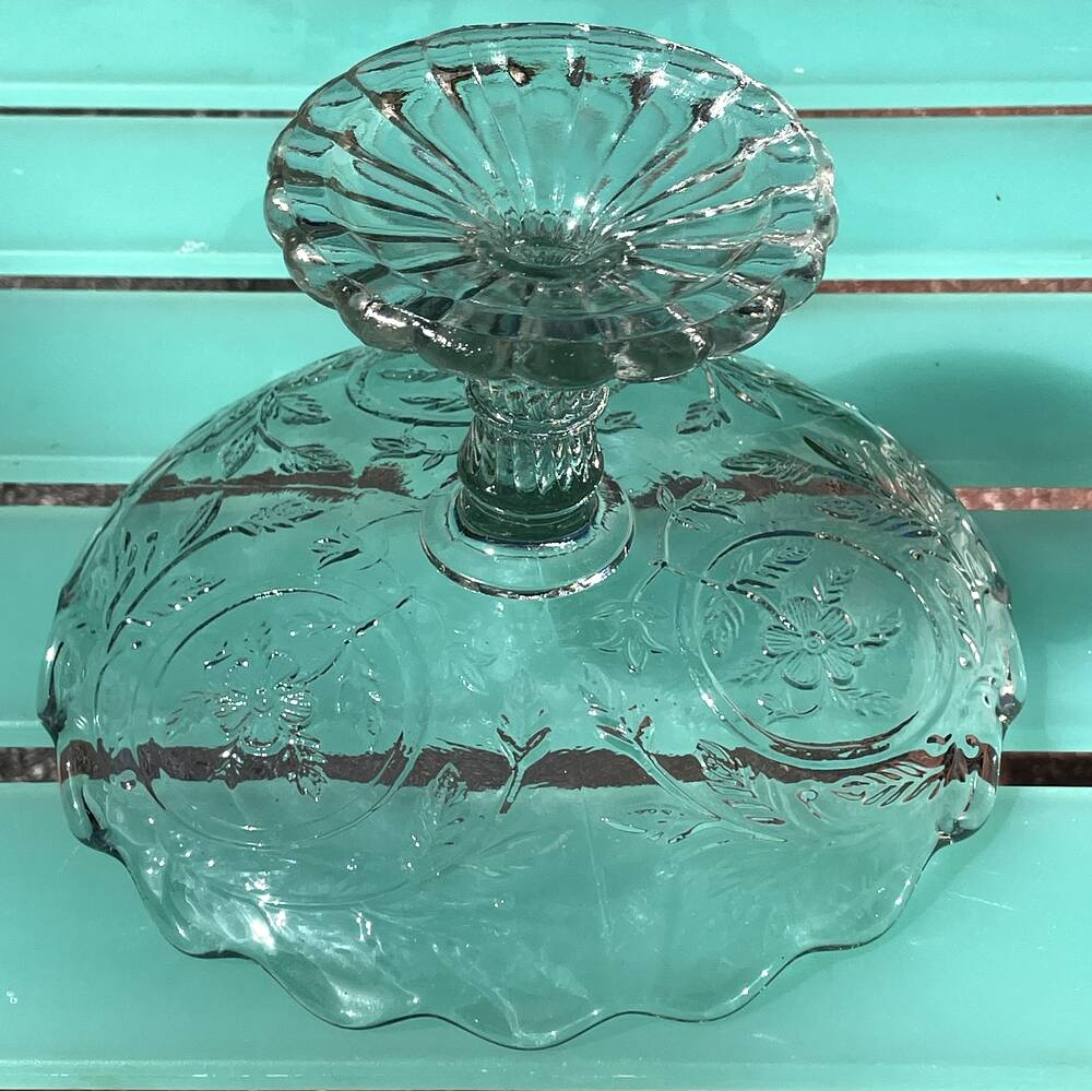 Footed bowl or pressed glass compote with floral decoration for table decor.