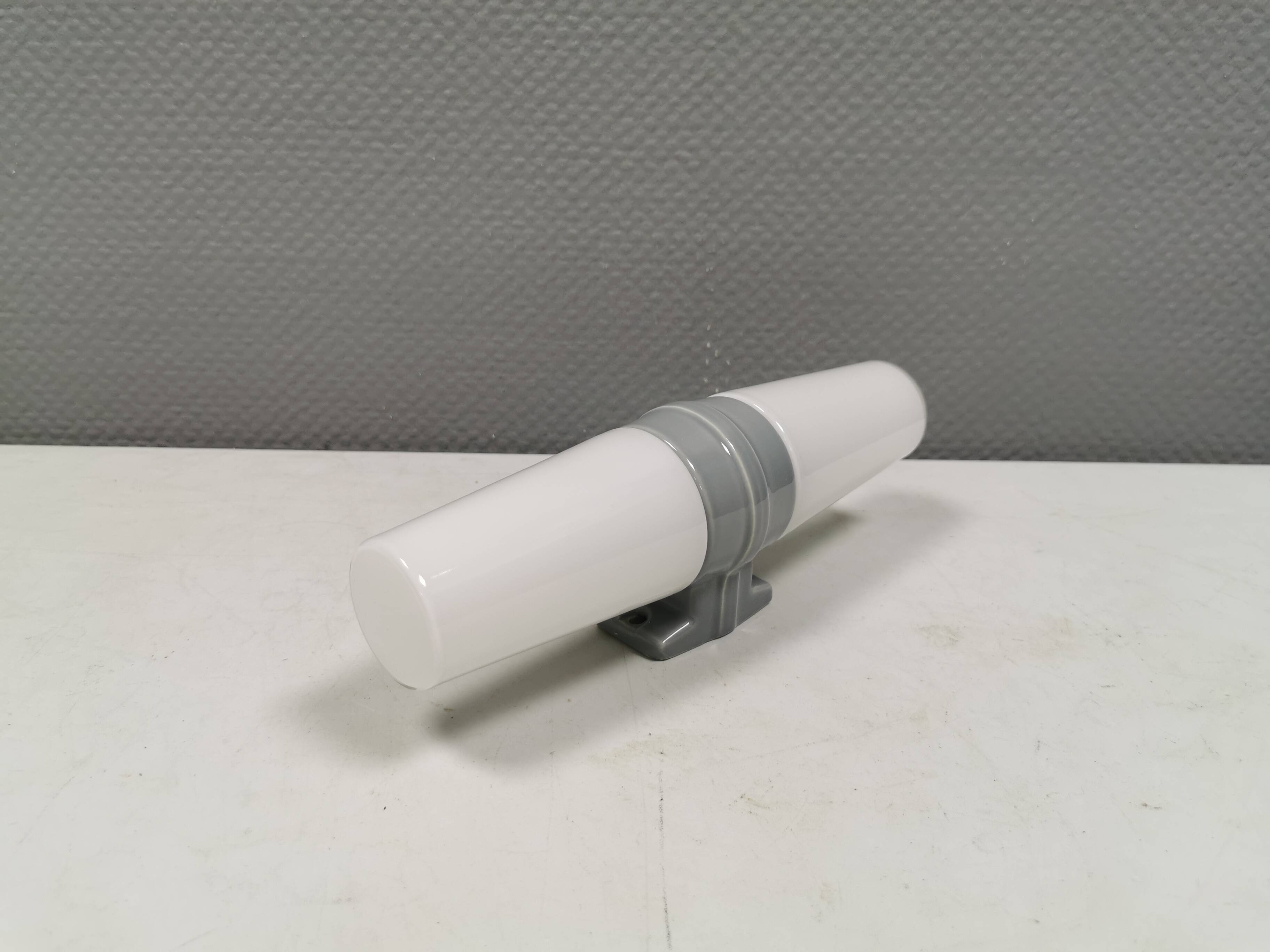 Bathroom lamp with light gray ceramic base,  and milky white opal glass.