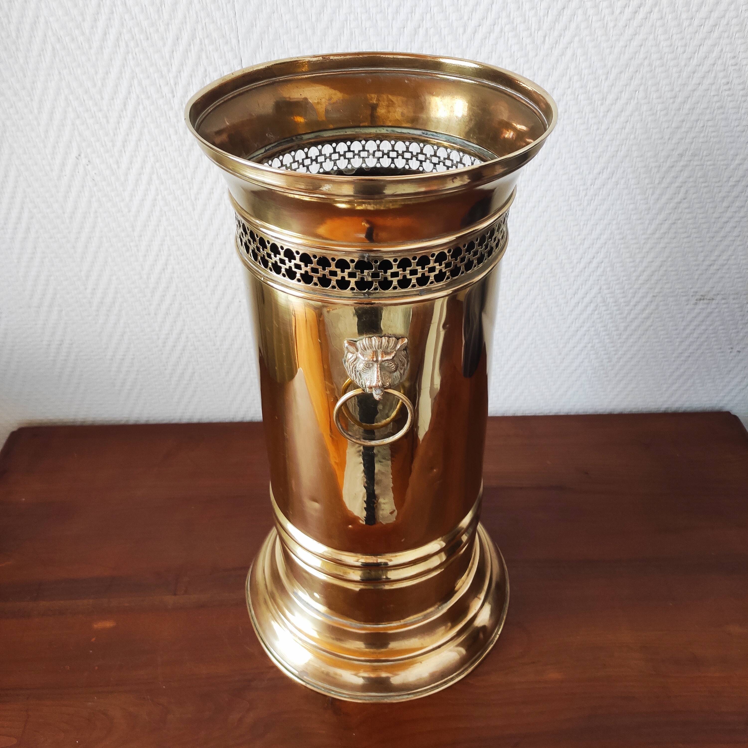 Vintage brass umbrella stand with lion decoration.
