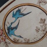 Large antique plate stamped with a fauna and flora pattern.