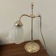 Articulated brass lamp with glass shade, early 20th century.
