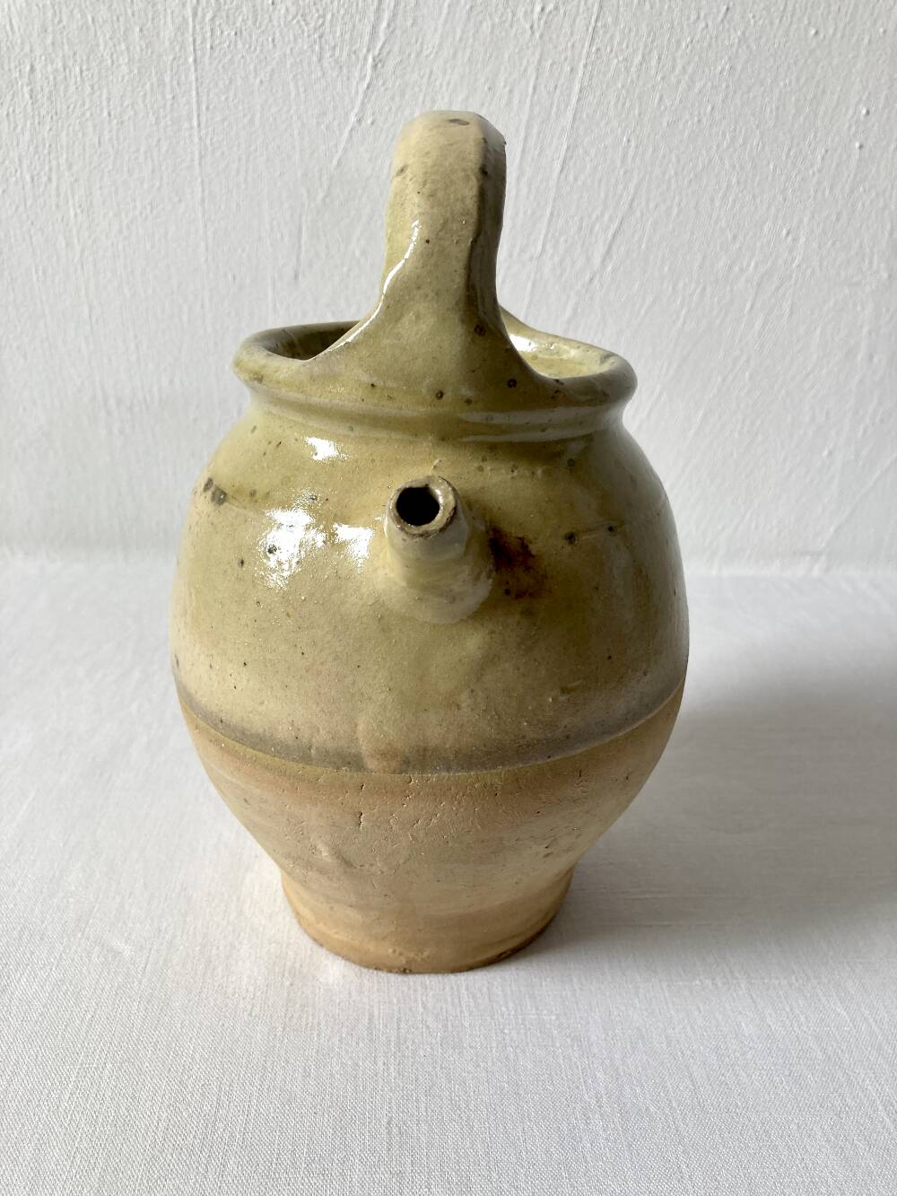 Old small goat-shaped jug in ochre glazed stoneware.