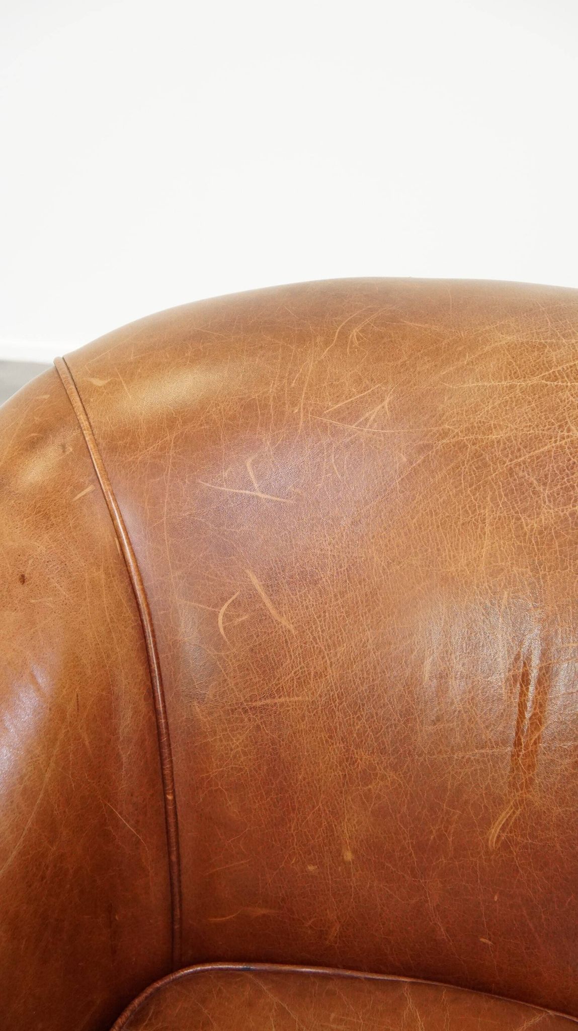 Very comfortable, elegant leather club armchair with a removable seat cushion and timeless design