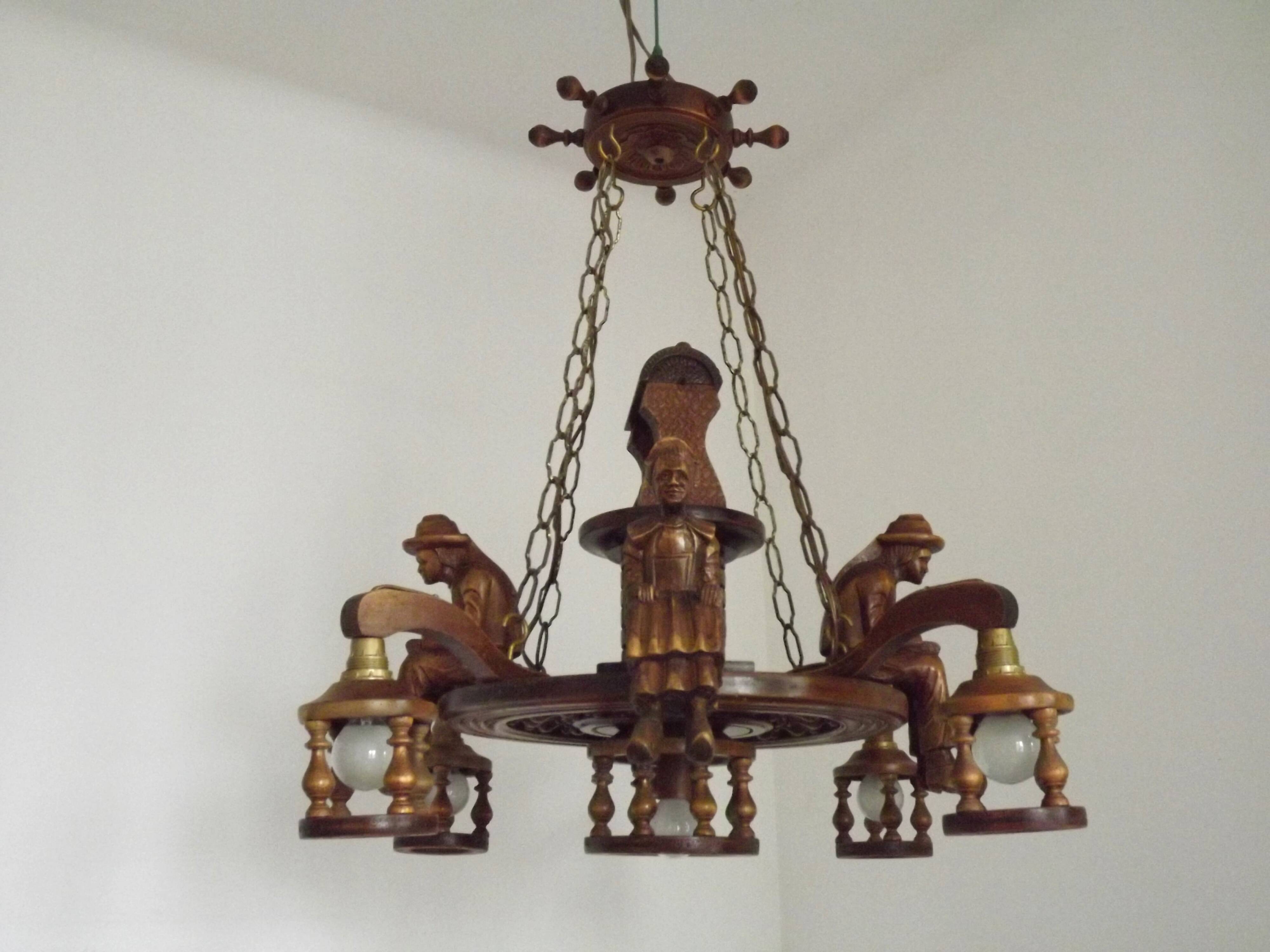French vintage Breton chandelier with hand-carved figures, well, and lantern lights.