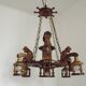 French vintage Breton chandelier with hand-carved figures, well, and lantern lights.