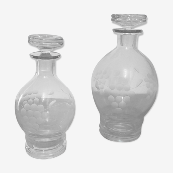 Duo of chiseled glass decanters, grape bunch decoration