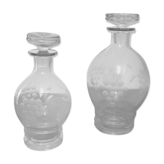Duo of chiseled glass decanters, grape bunch decoration