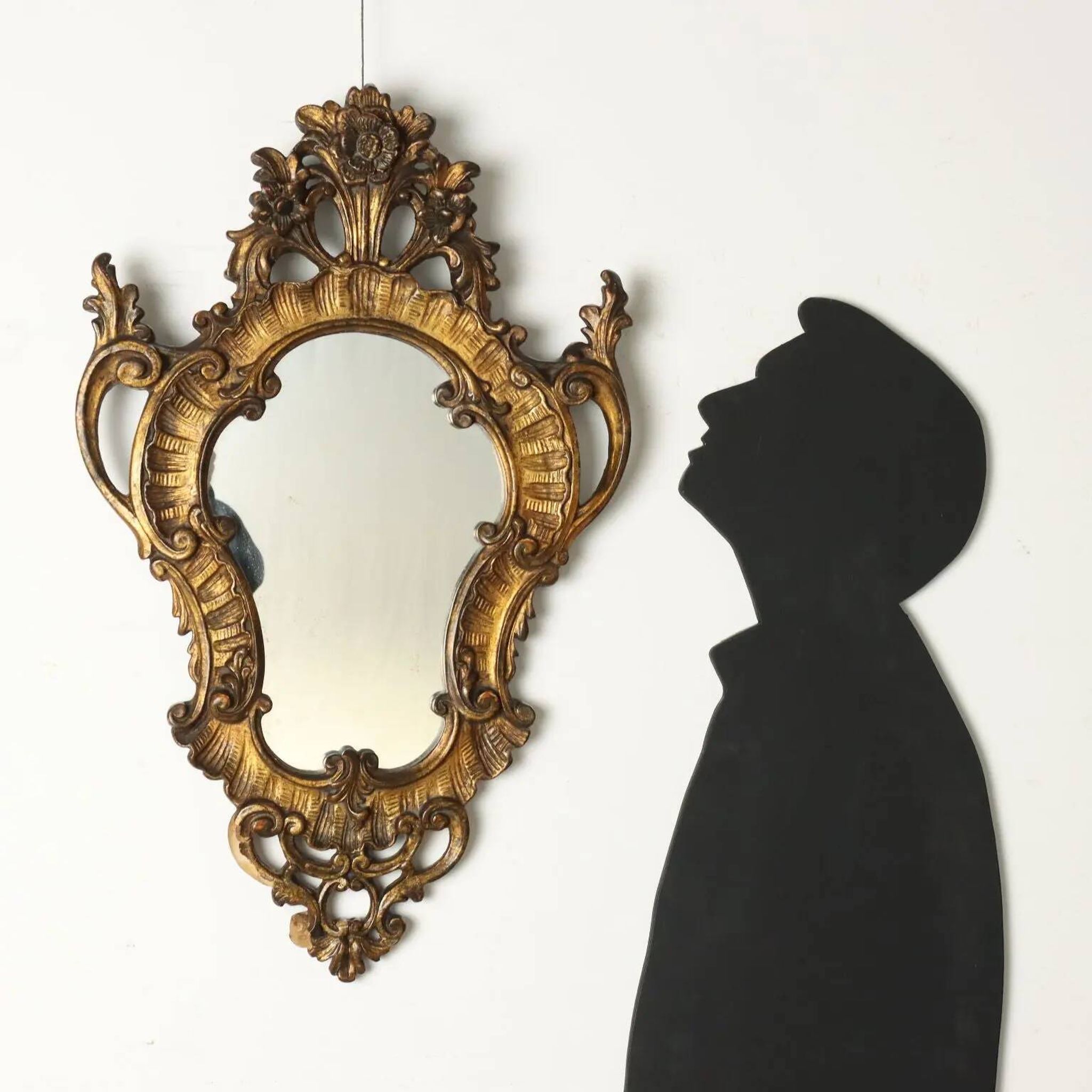Antique Rococo-style mirror, gilded linden decorations, 20th century.