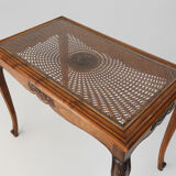 Side table with sculpted elements and rattan top