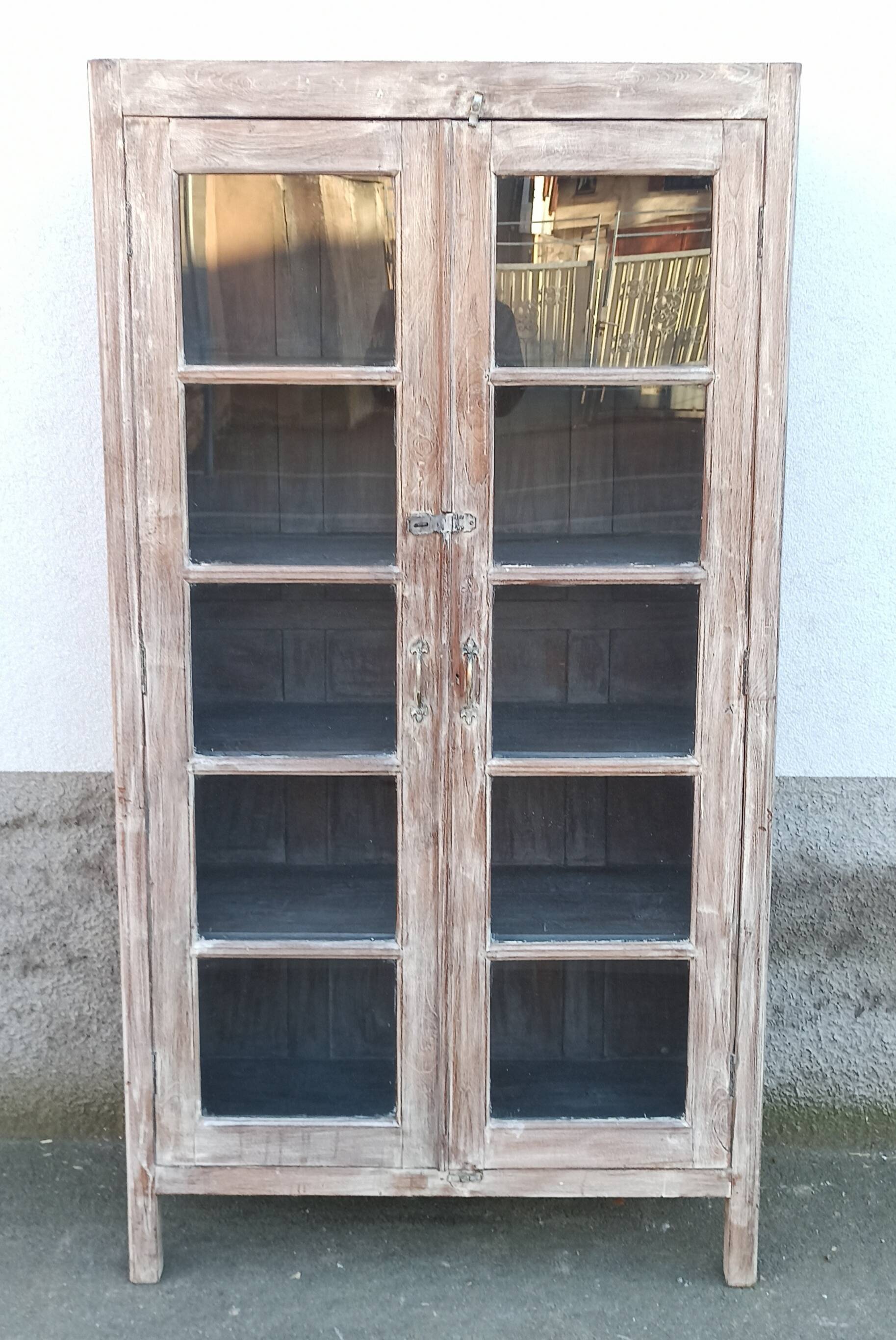 Glass cabinet in old whitewashed wood