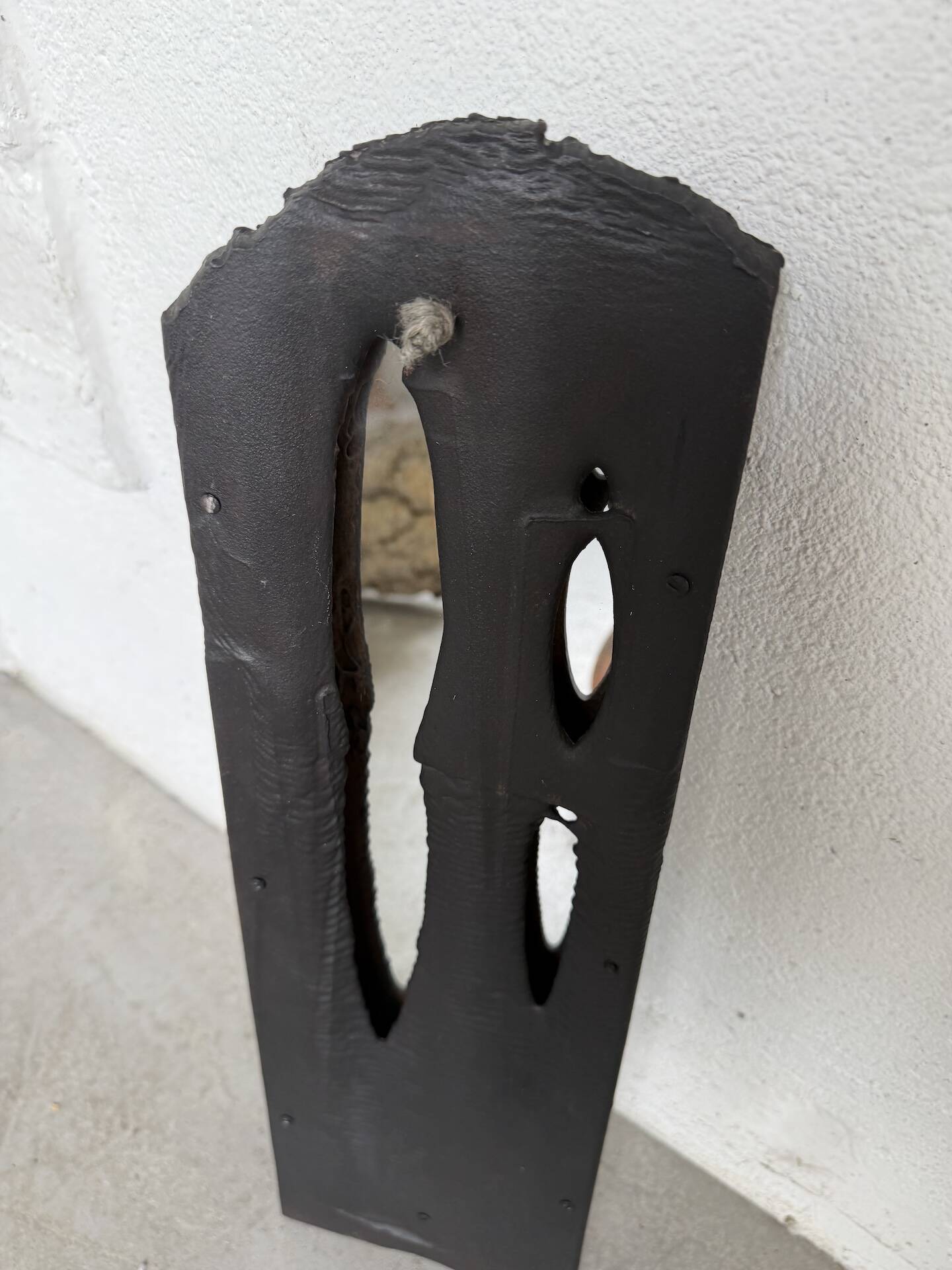 Brutalist hammered mirror, free-form, patinated metal.