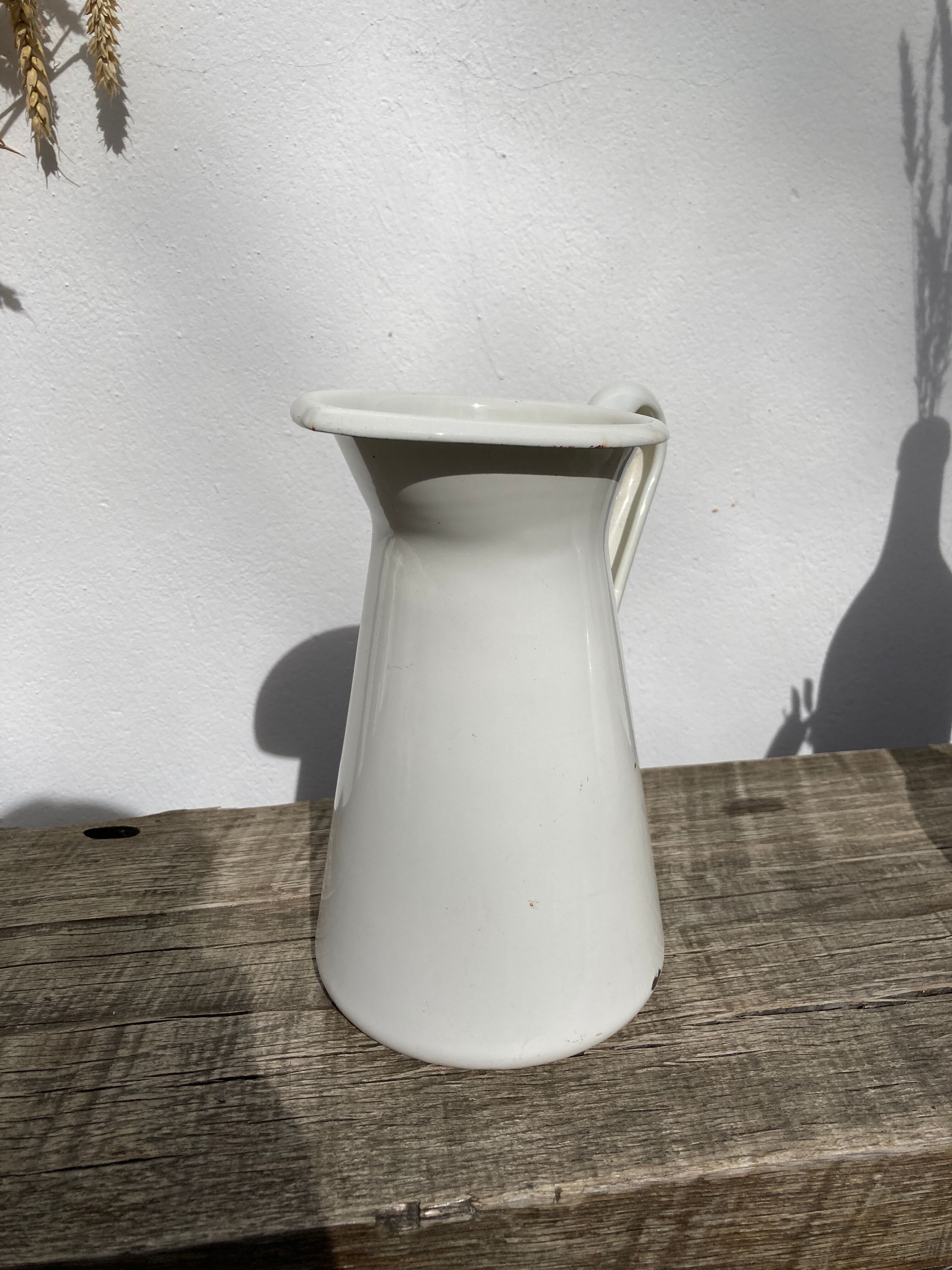 Old white enamelled metal pitcher