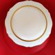 Round plar in Montanbert art porcelain. White rimmed with matte gold.