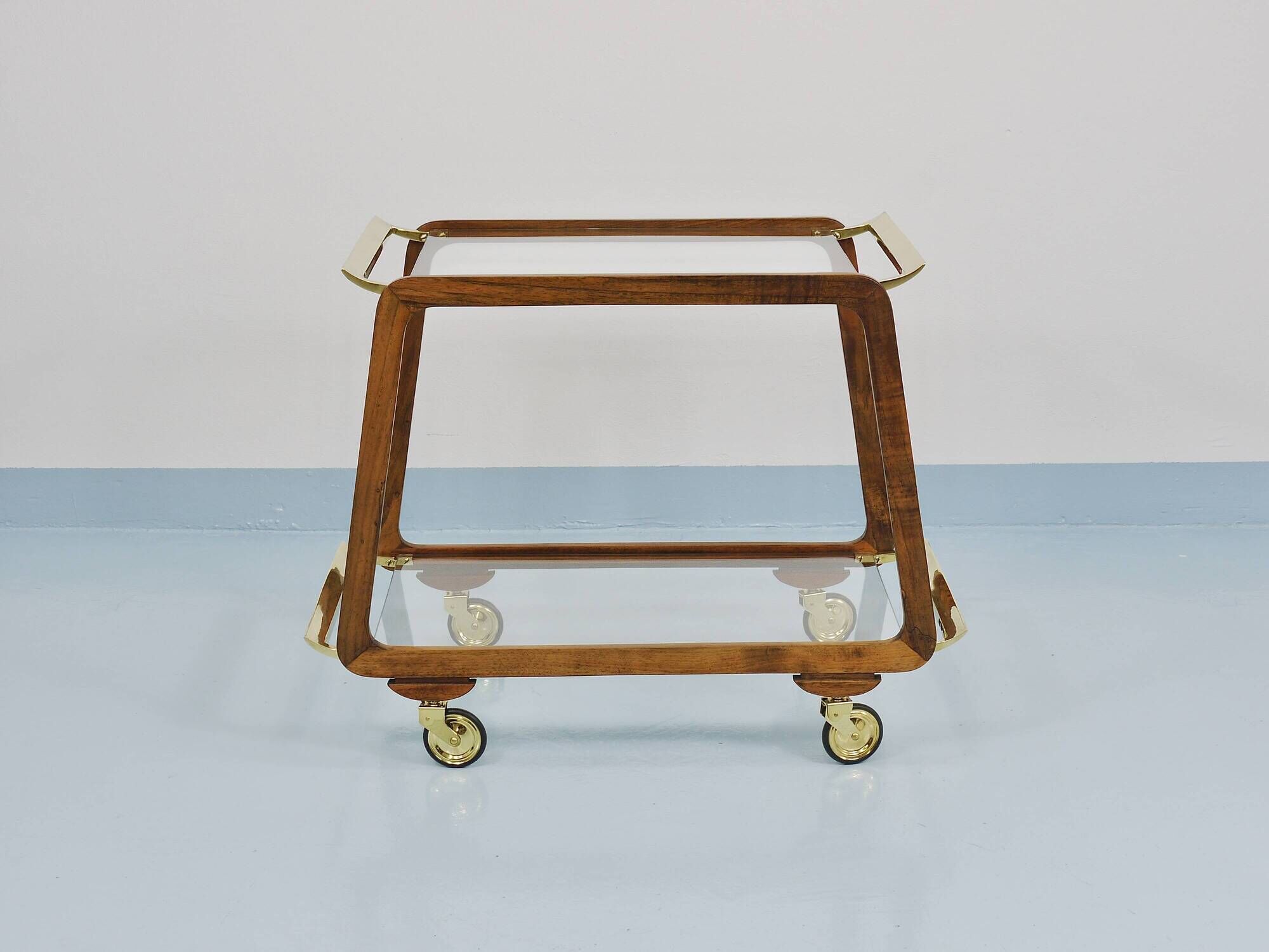 May include: A mid-century modern bar cart with a dark wood frame and two c
