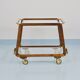 May include: A mid-century modern bar cart with a dark wood frame and two c
