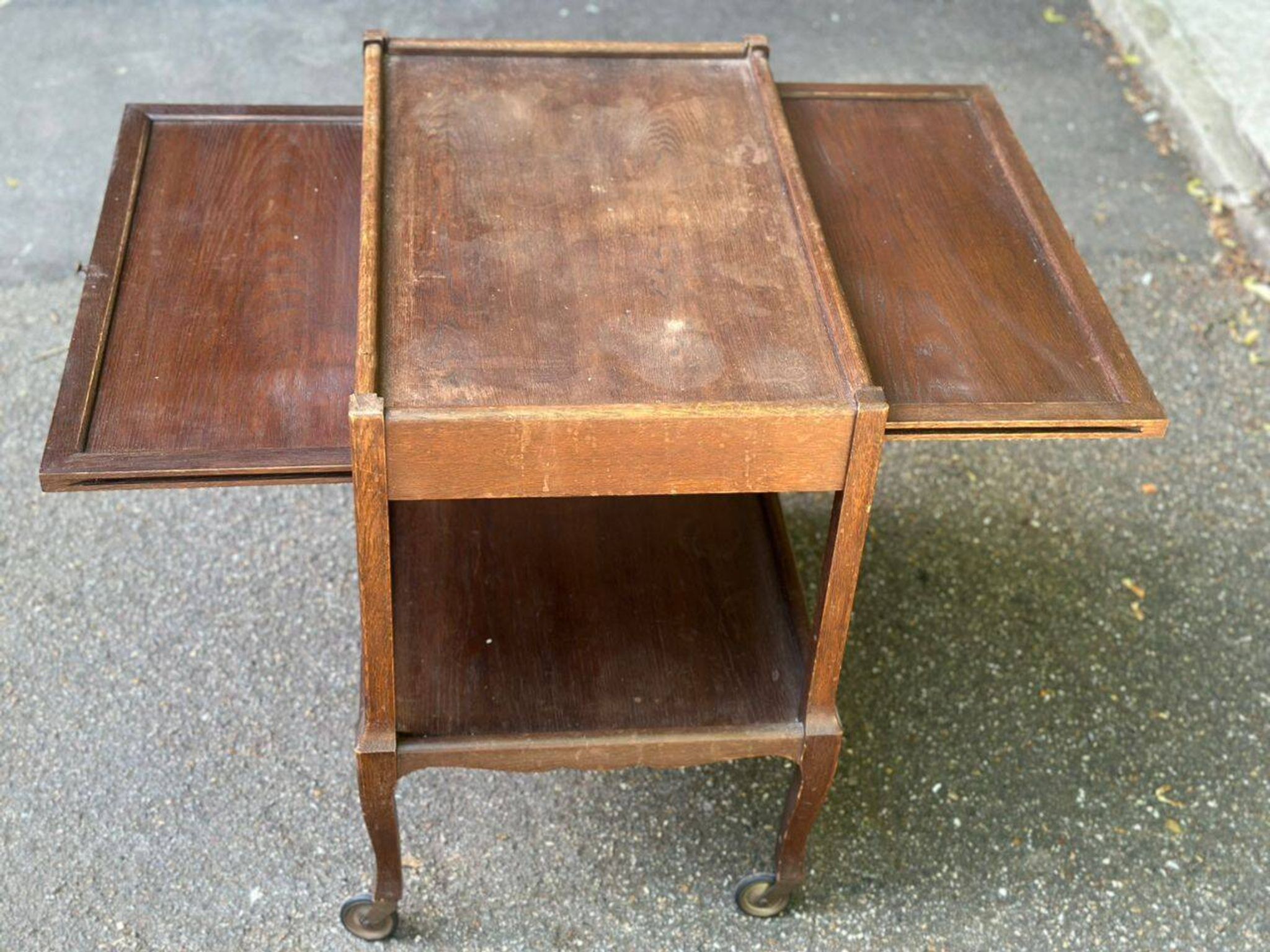 Extendable wooden bar trolley with a glass top from the 1930s.