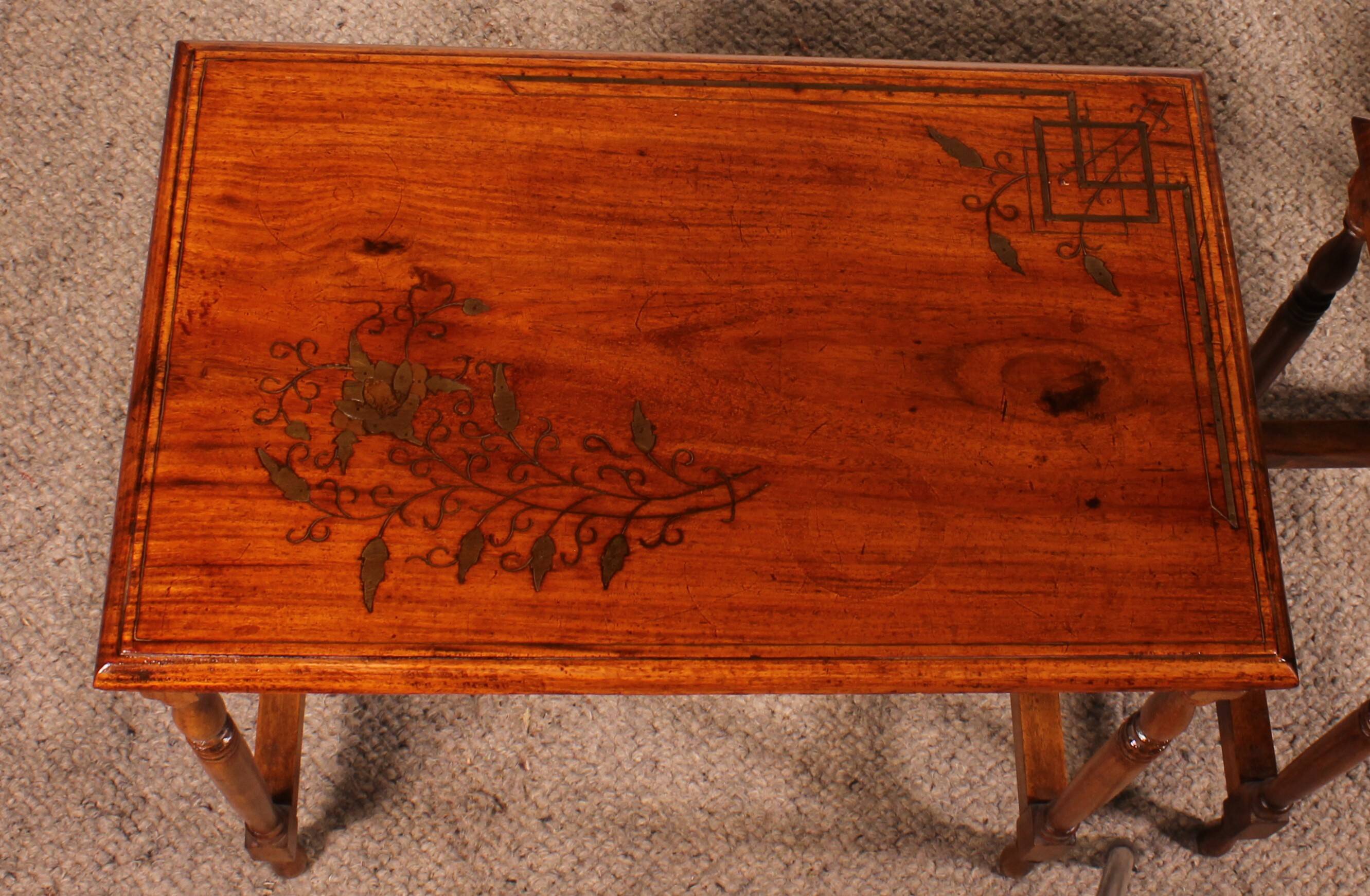 Nested tables in satin wood with brass inlays.