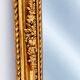 Grand miroir baroque en or avec un crête orné.
