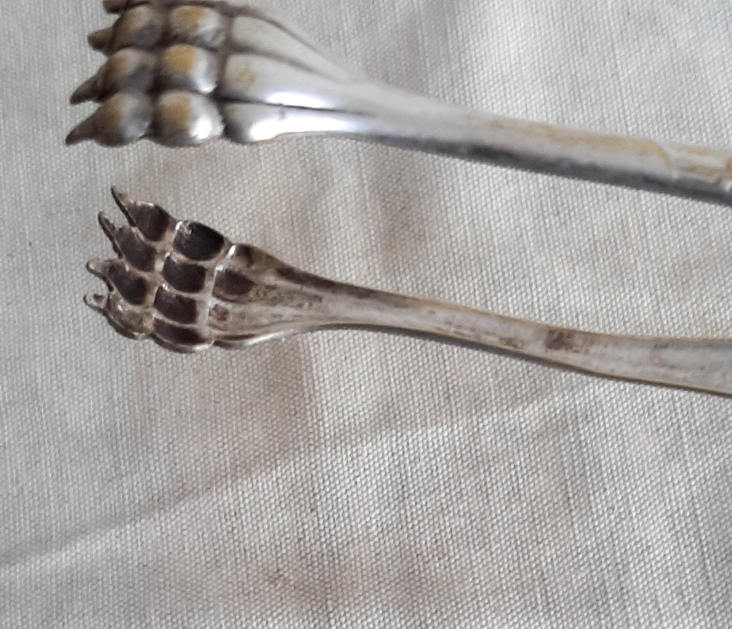 Antique silver-plated sugar tongs with lion's paws.