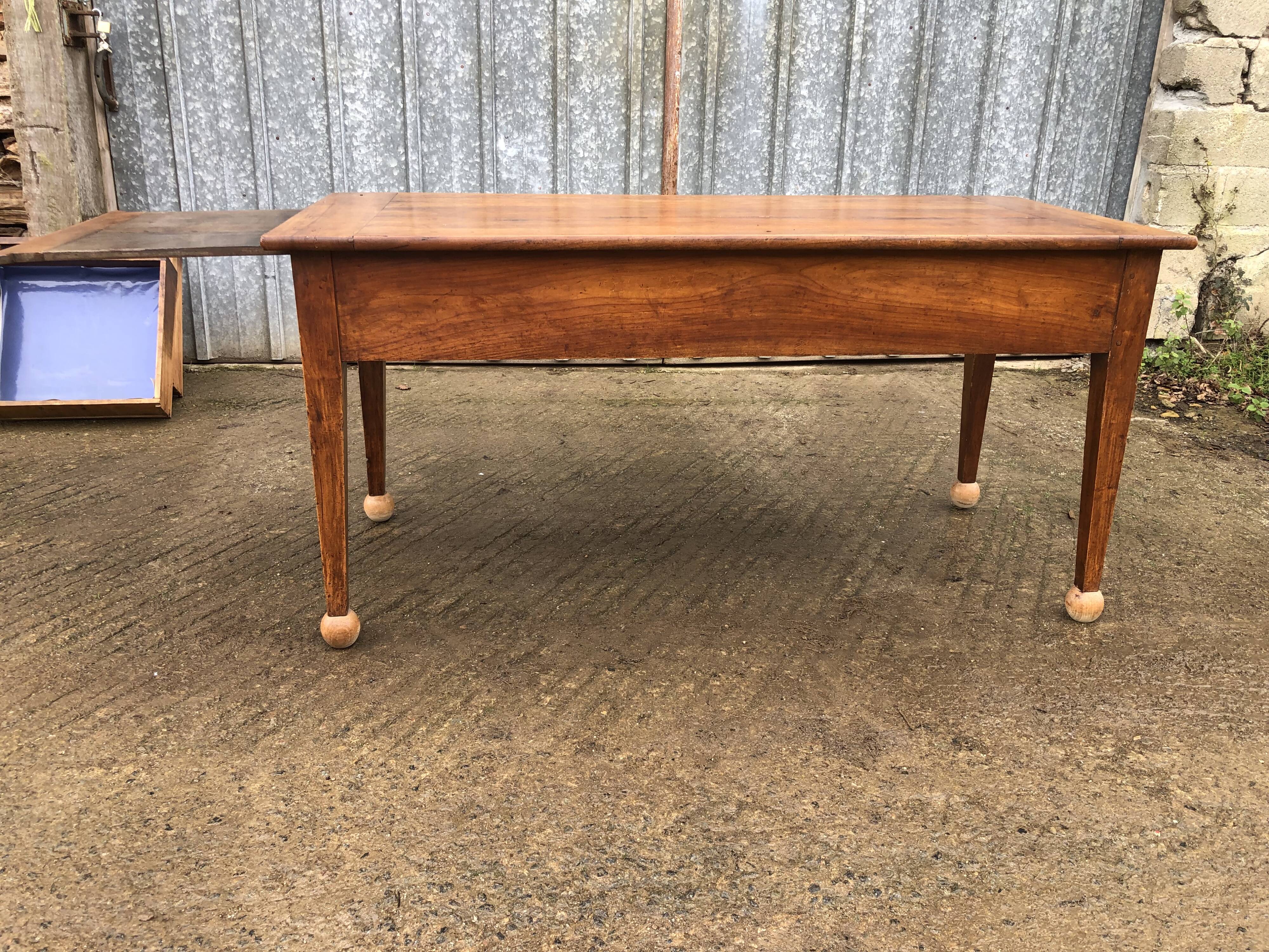 Antique solid cherry farmhouse table with 2 end drawers and 1 pull-out.