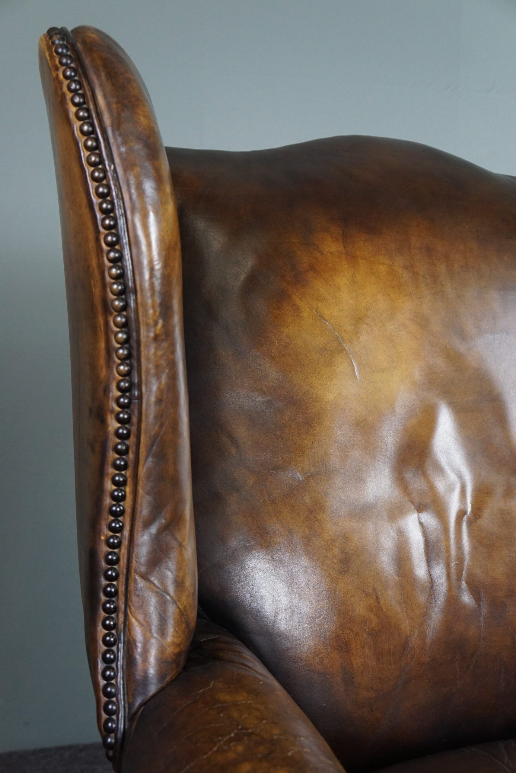 Patinated cowhide leather armchair