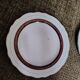 Salins white ceramic dessert plates with red trim and gold rim.