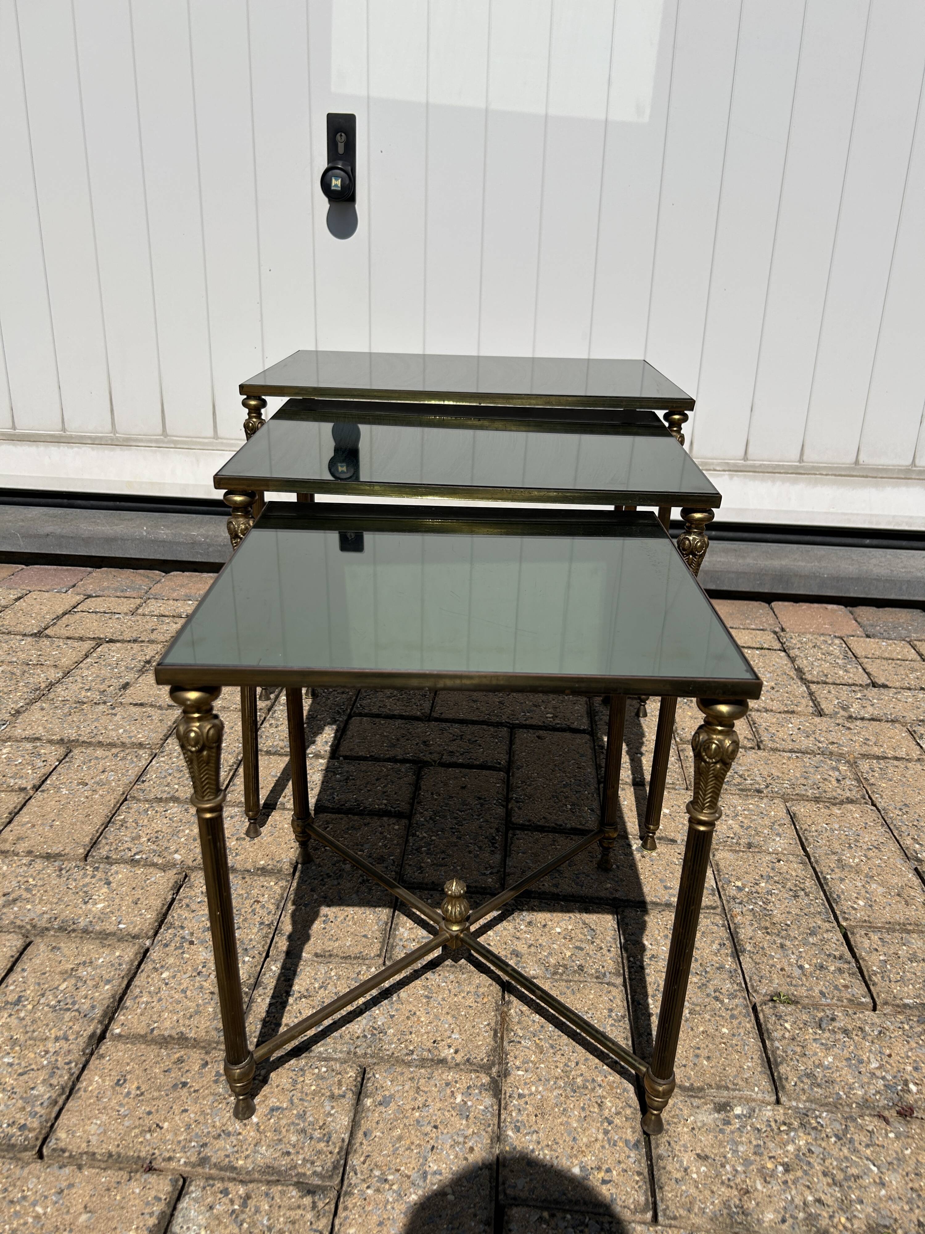 Nested tables in gilded brass in the style of Maison Charles.