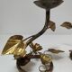Pair of brass candle holders decorated with patinated metal flowers