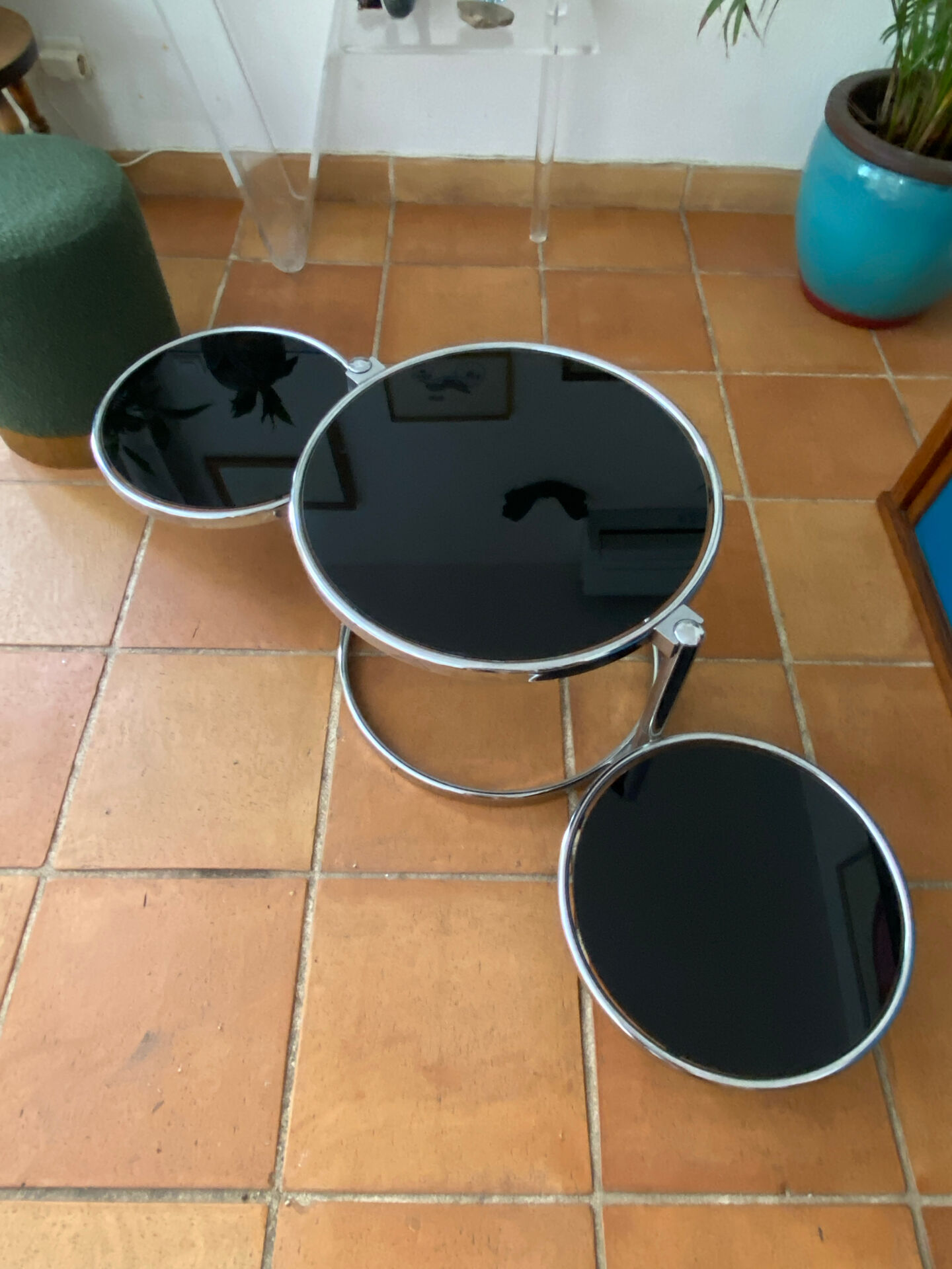 Coffee table with pivoting metal and black glass elements.