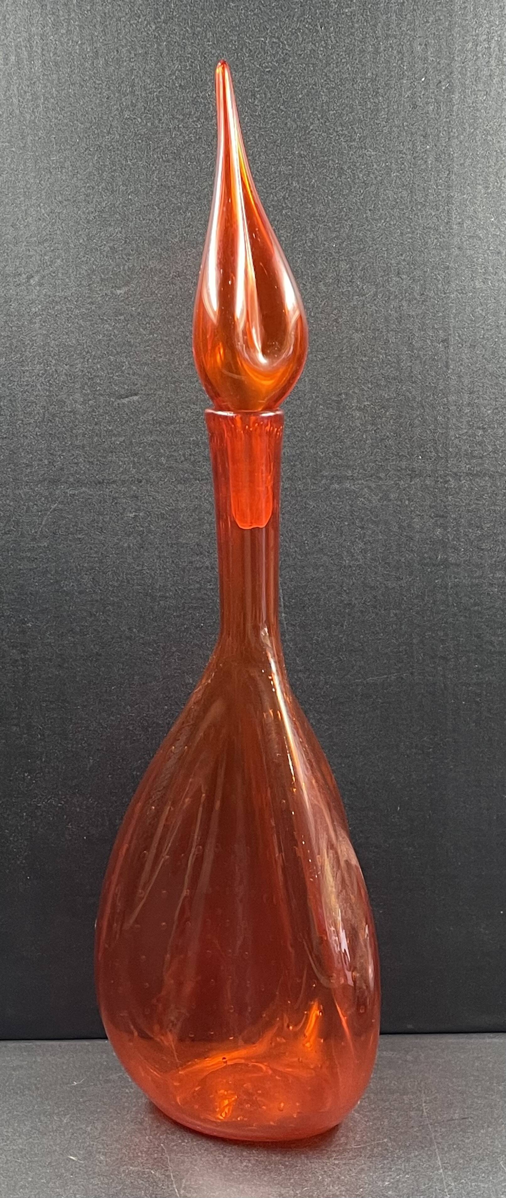 Orange bubbled glass bottle with curved body, circa 1970