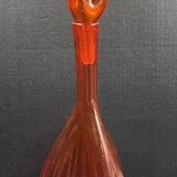 Orange bubbled glass bottle with curved body, circa 1970