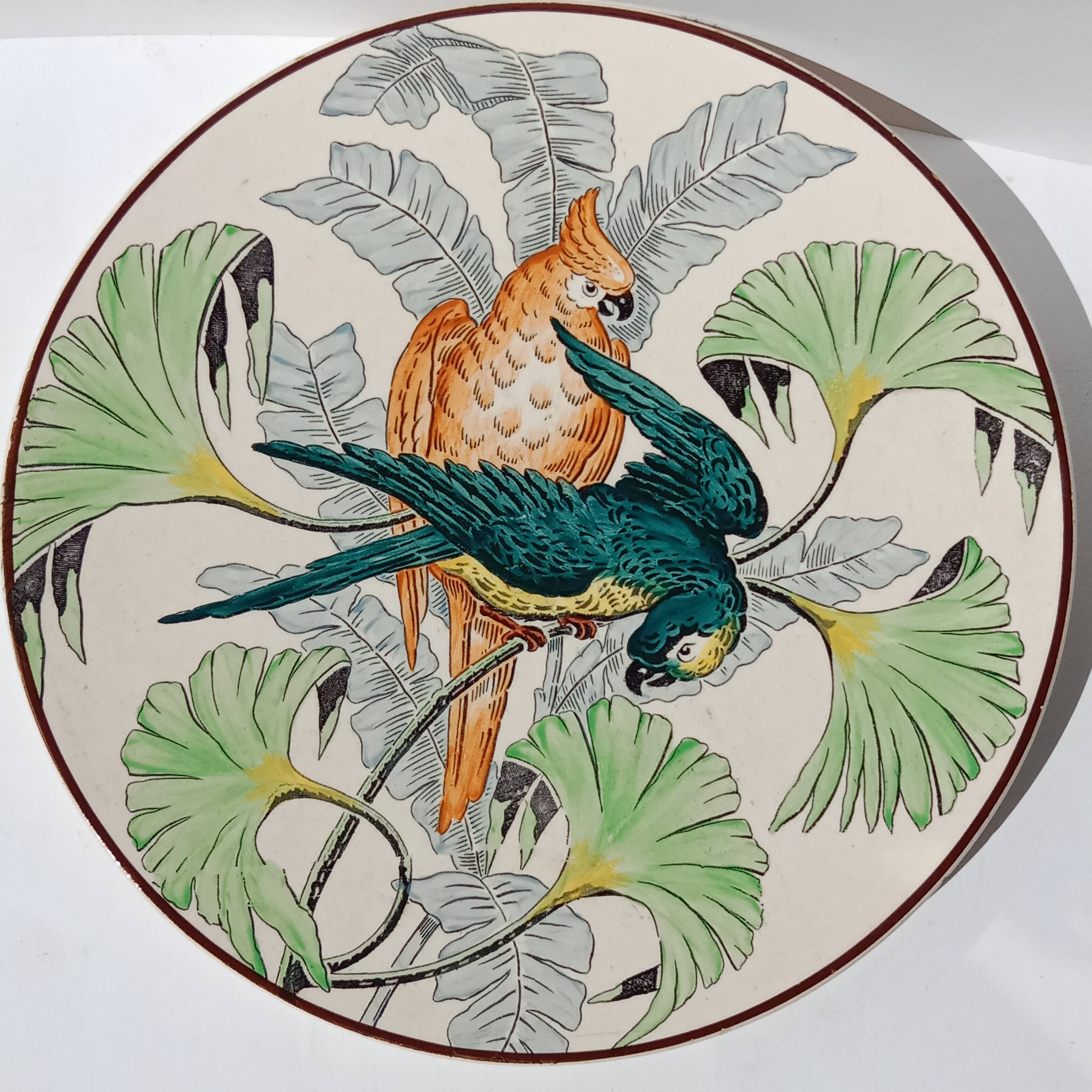 Plat rond à décor de perroquets dans la jungle, circa 1900