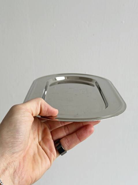 Small antique tray made of lightweight metal.