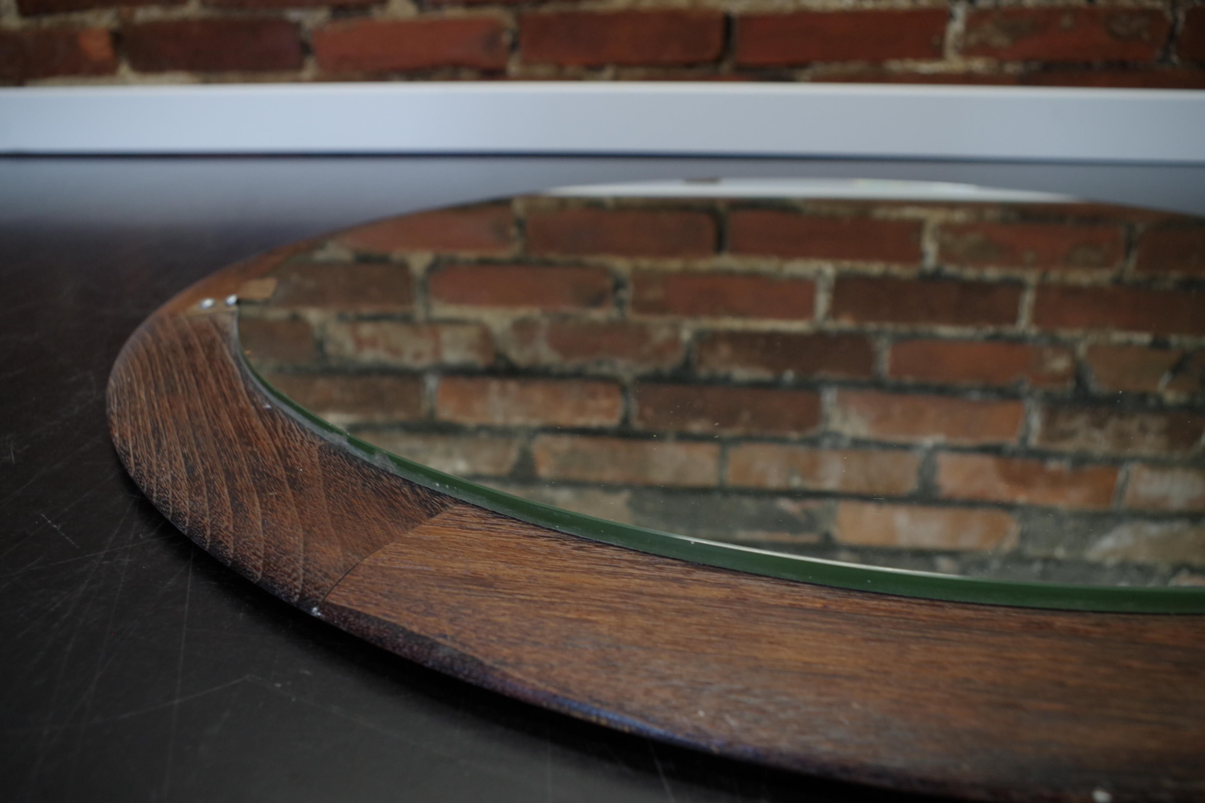 Round mirror in a vintage teak wood frame