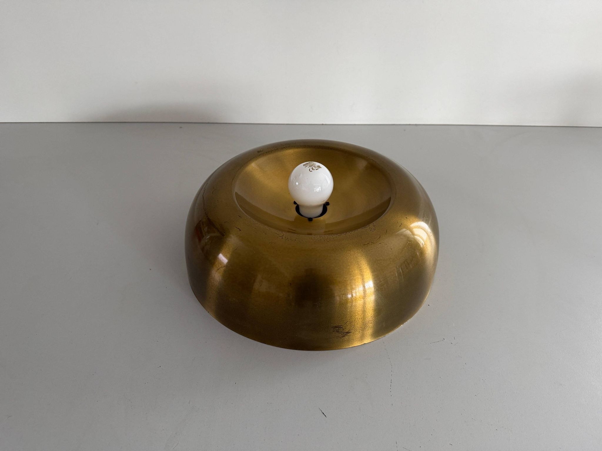 Flush-mounted disc-shaped brass fixture from the mid-century, 1960, Italy.