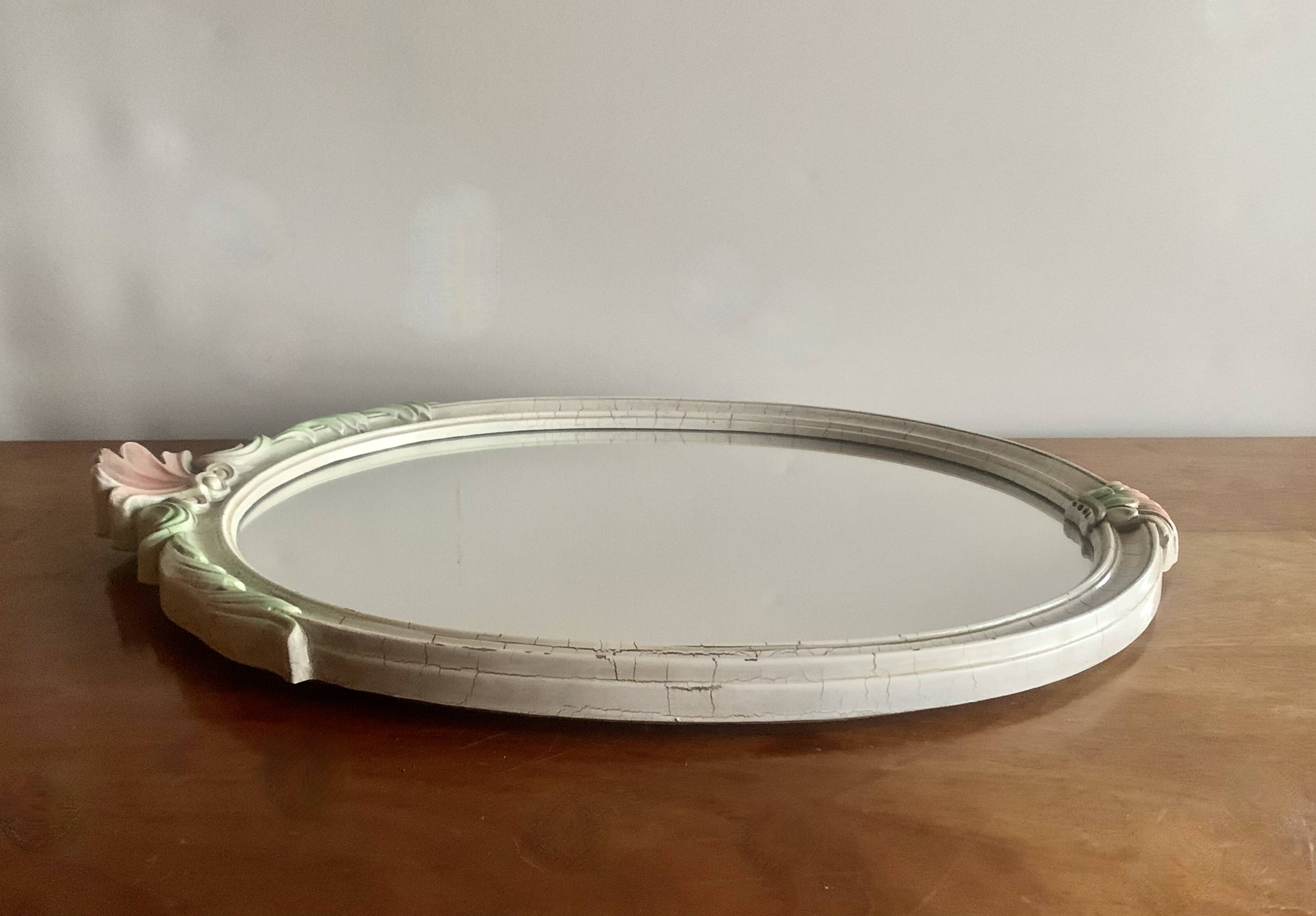 Vintage oval mirror in carved wood in pastel tones