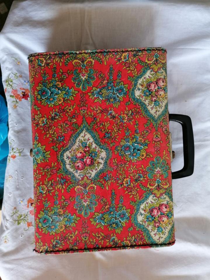 Old suitcase, red cashmere fabric, bohemian folk