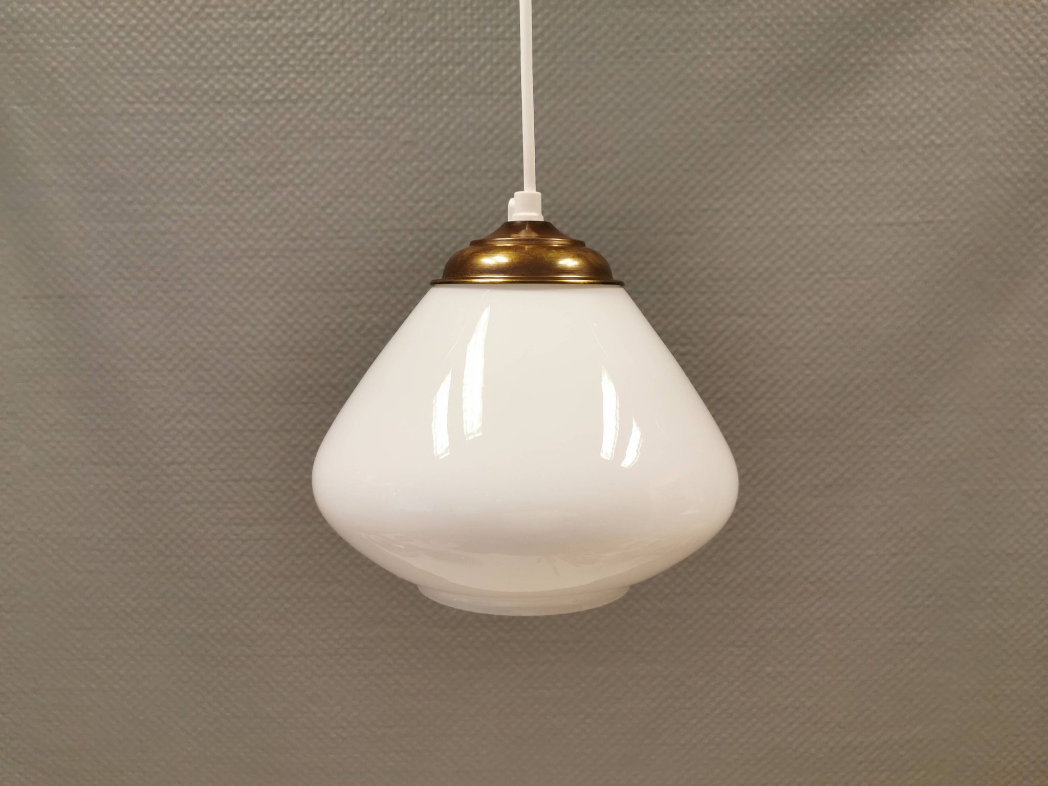 Beautiful ball-shaped hanging lamp in white opal glass with brass top.
