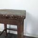 Brown painted wooden workshop stool with a patinated top.