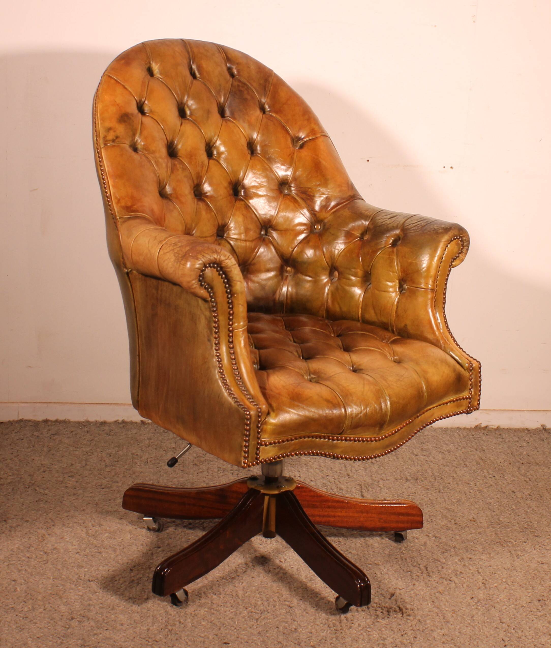 Office chair known as a presidential chair in mahogany and cognac leather.