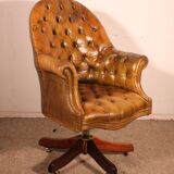 Office chair known as a presidential chair in mahogany and cognac leather.