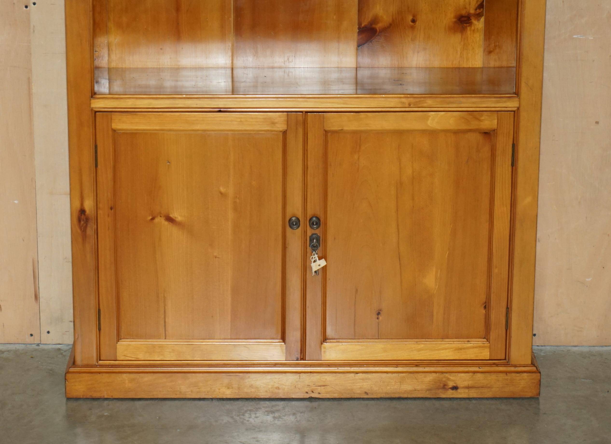 Pair of vintage cherry wood bookcases with lockable doors.