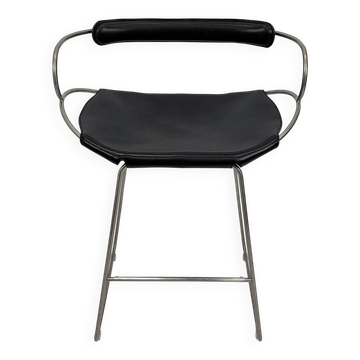 Kitchen stool with a weathered silver steel backrest and black seat.