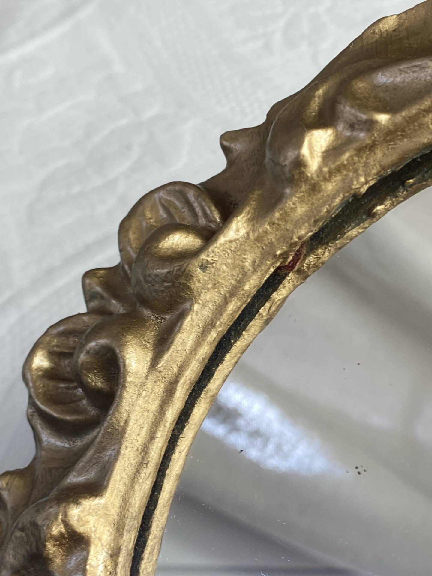 Round wooden mirror in golden colour.
