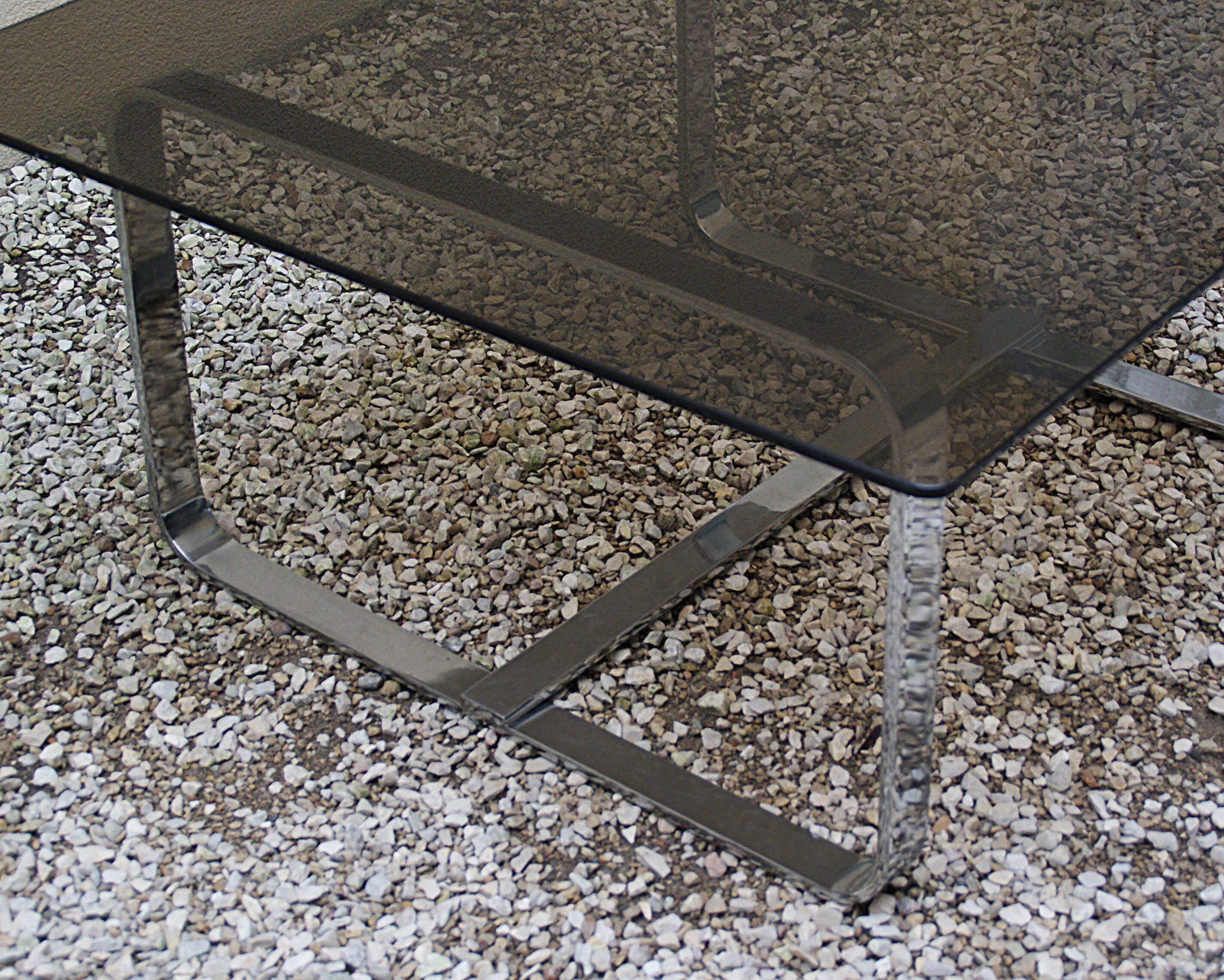 Table basse Roche Bobois 1970 verre fumé piètement en métal chromé.