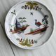 Hand-painted earthenware plate with landscape and bird decoration.