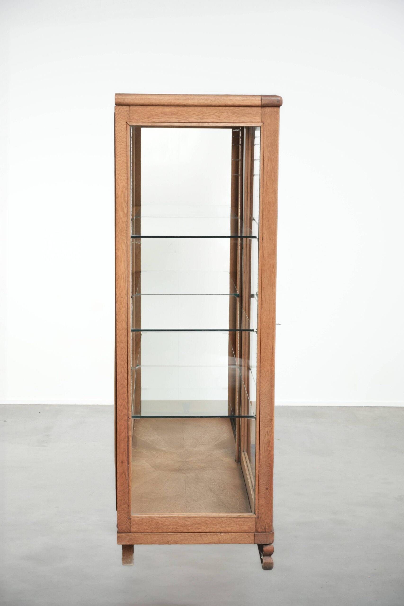 Antique Dutch oak display cabinet with glass shelves and a mirrored back