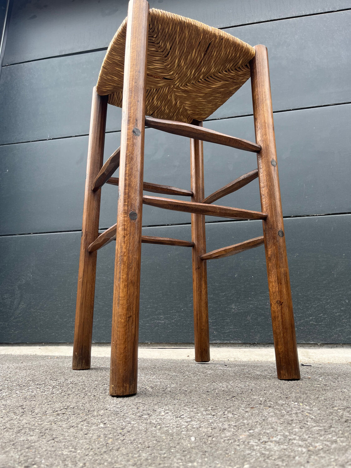 Old high bar stool in wood and straw